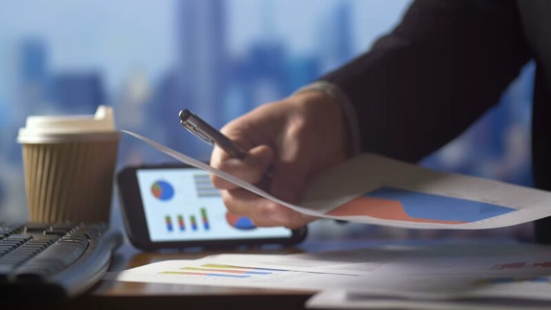 business person working on finance forms at desk on calculator